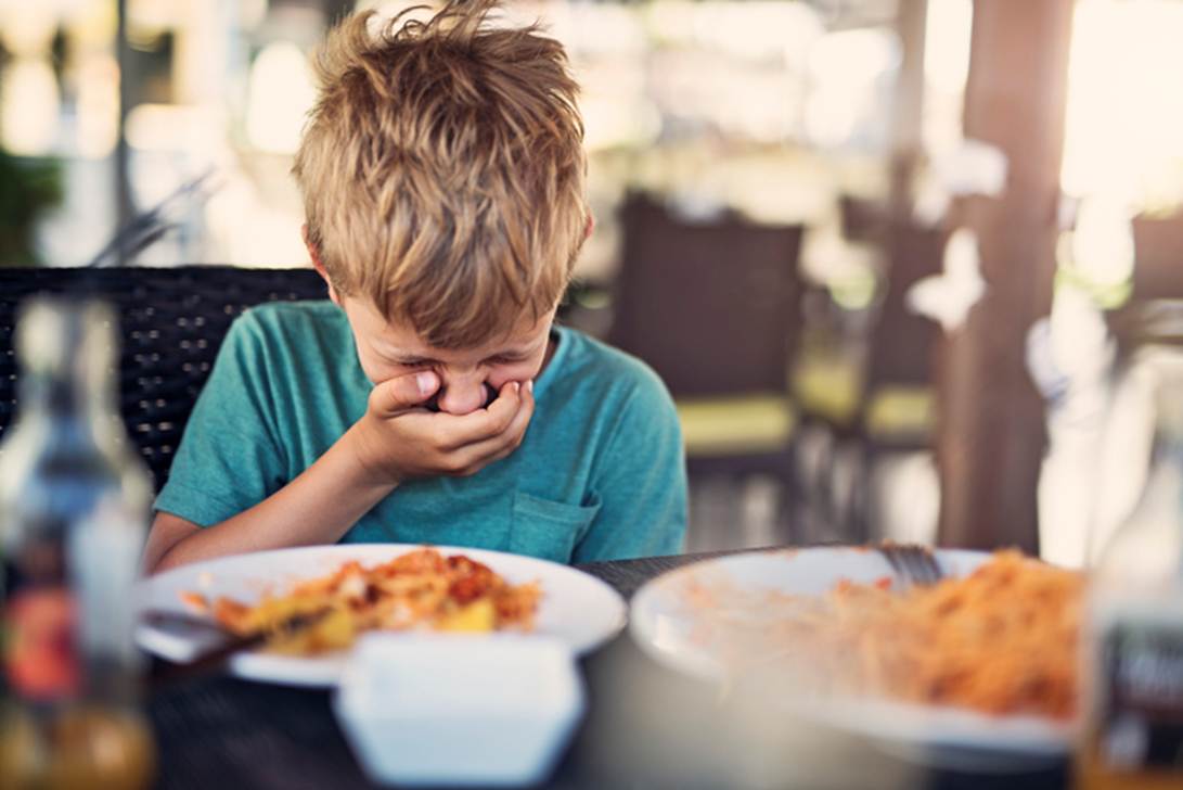 A child crying in front of plates of food
AI-generated content may be incorrect.